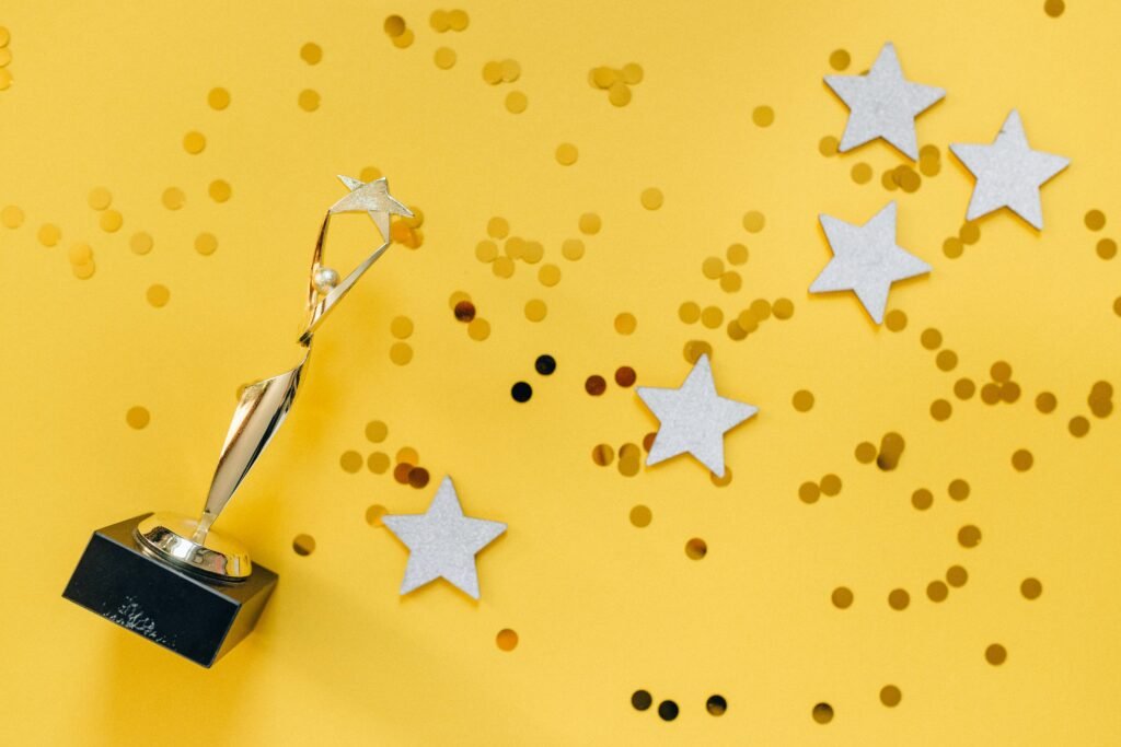 pexels photo 6532373 6532373 Shiny golden trophy and stars on a vibrant yellow background, symbolizing success and victory.